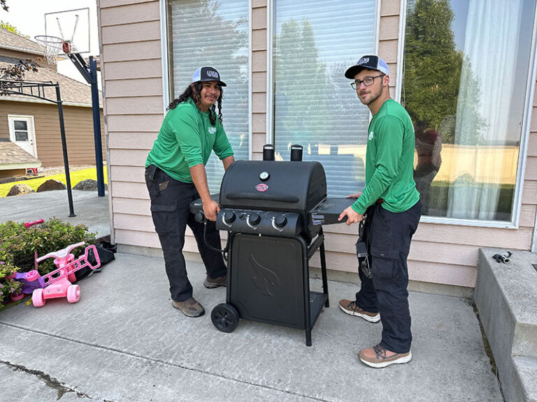 Legend Junk Removal team lifting griller during junk removal service