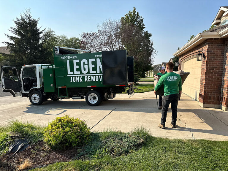 Legend Junk Removal specialists hauling and loading couch to the junk truck