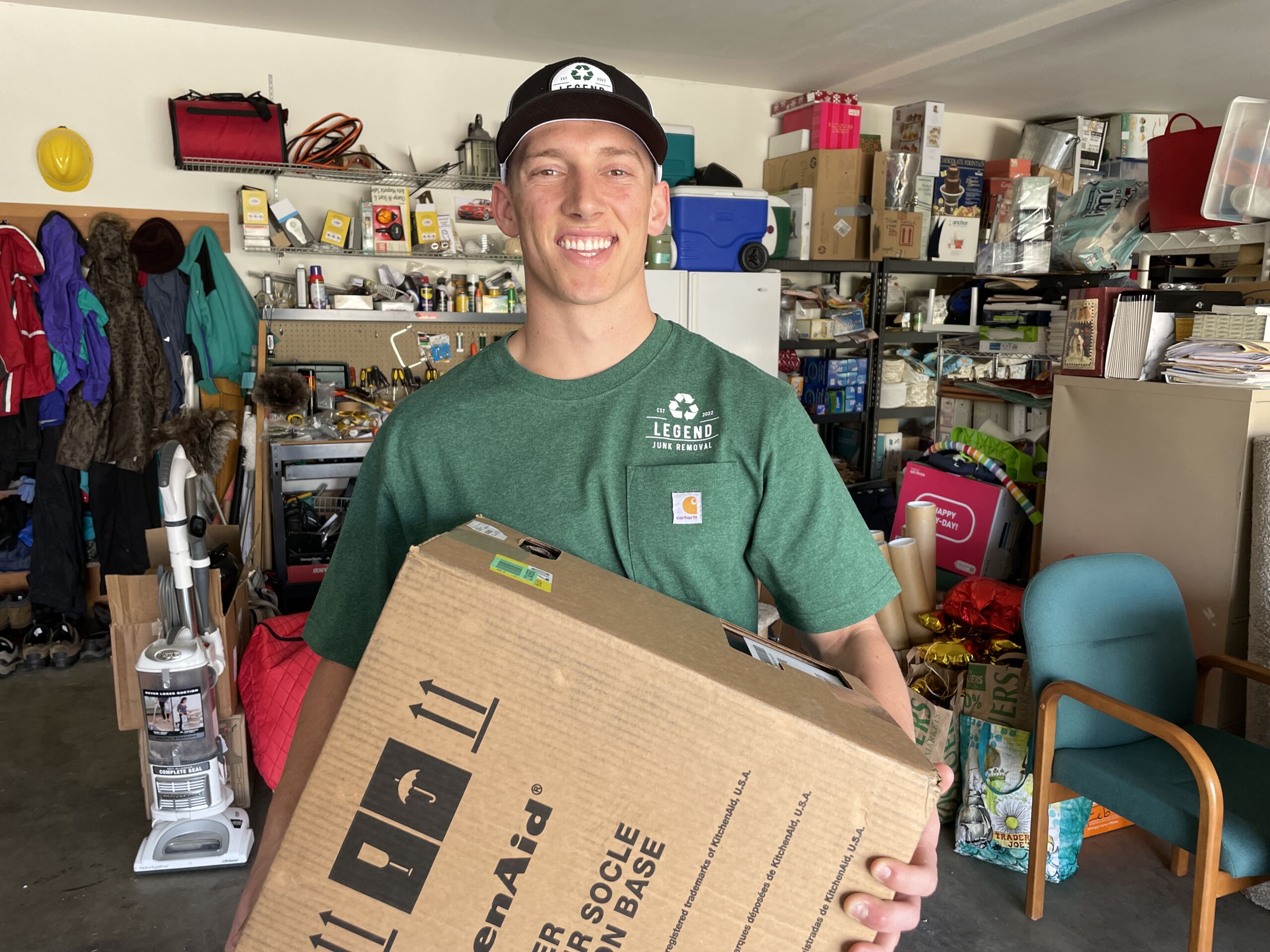 Legend Junk Removal professional easily removing a box of junk during garage cleanout services in WA
